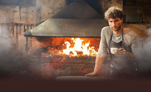 Мъж, стоящ пред камина, наслаждаващ се на чаша кафе от Nova Brasilia